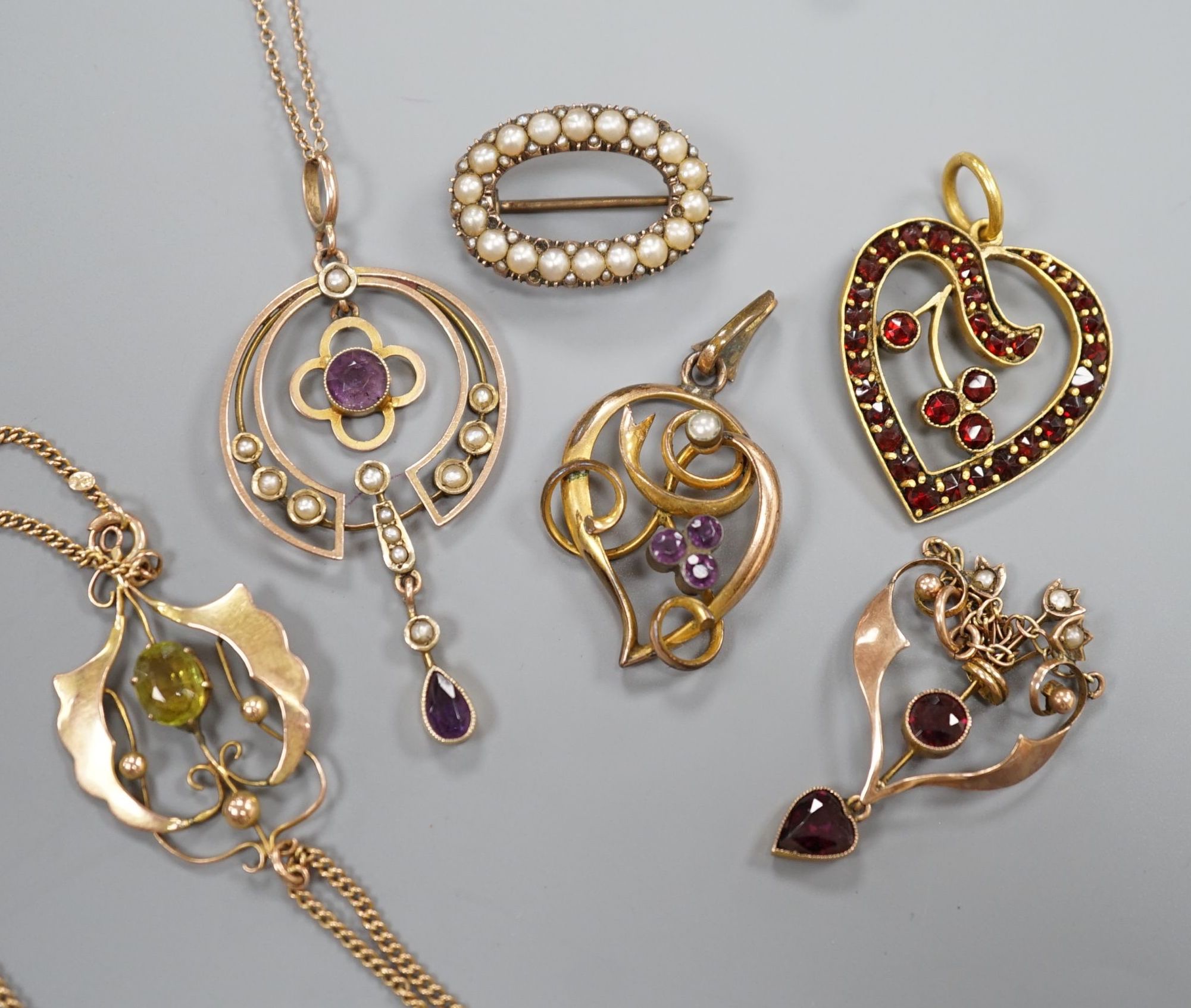 Three early 20th century yellow metal and gem set drop pendants, including two stamped 9ct and two with 9ct chains, largest 5cm, gross weight 10.1 grams, two other pendants and a yellow metal and split pearl set oval bro